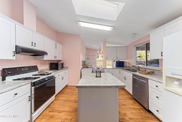 kitchen featuring light hardwood / wood-style floors, white cabinets, appliances with stainless steel finishes, and a center island