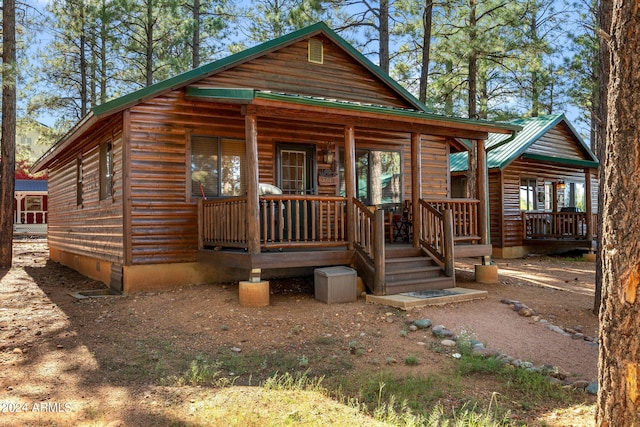 log-style house with covered porch