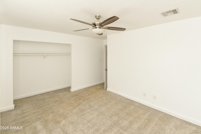 unfurnished bedroom featuring light carpet, a closet, and ceiling fan