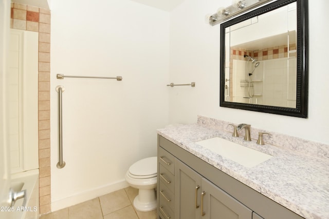 bathroom featuring tile patterned flooring, vanity, a tile shower, and toilet