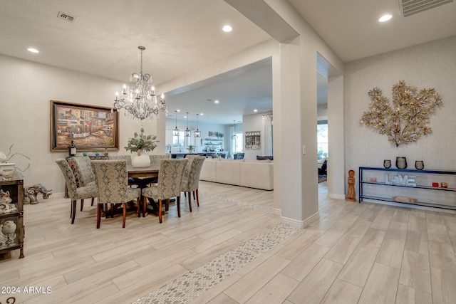 dining room with light hardwood / wood-style flooring and a notable chandelier