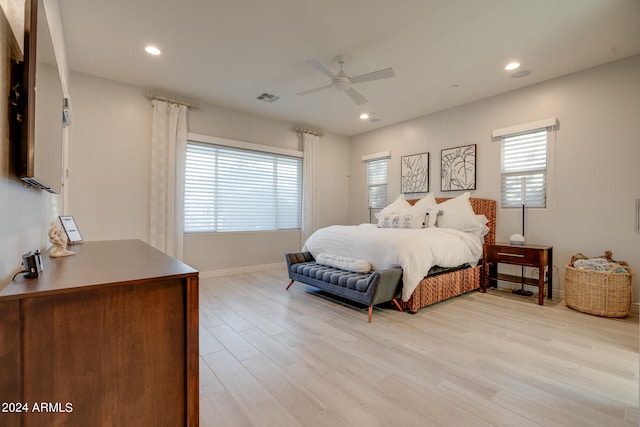 bedroom with multiple windows, light hardwood / wood-style flooring, and ceiling fan