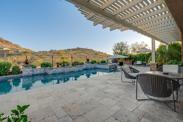 view of swimming pool with a mountain view, a pergola, and a patio area