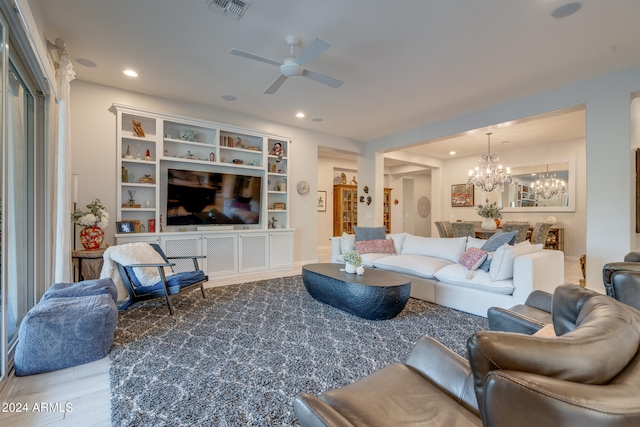 living room featuring light wood-type flooring and ceiling fan with notable chandelier