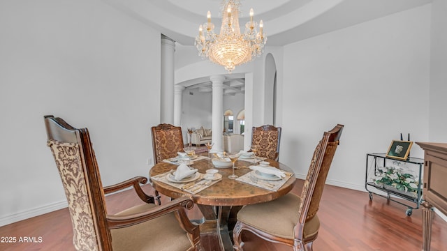 3126 E Fruitvale Ct, Gilbert, AZ 85297 - dining room featuring arched walkways, wood finished floors, decorative columns, a chandelier, and baseboards