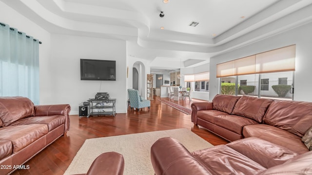 3126 E Fruitvale Ct, Gilbert, AZ 85297 - living room with a raised ceiling, arched walkways, dark wood-style flooring, and baseboards