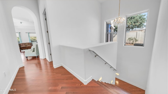 3126 E Fruitvale Ct, Gilbert, AZ 85297 - hall featuring an upstairs landing, wood finished floors, a chandelier, arched walkways, and baseboards