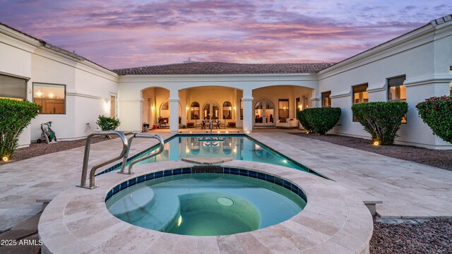3126 E Fruitvale Ct, Gilbert, AZ 85297 - pool at dusk featuring a patio area, a pool with connected hot tub, and french doors