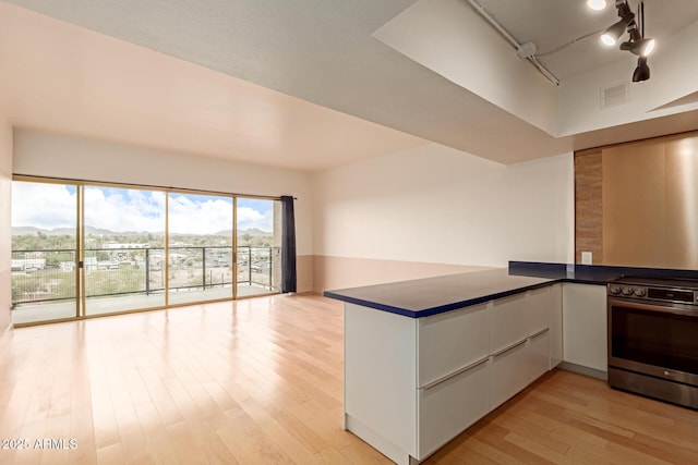 kitchen featuring white cabinetry, electric stove, light hardwood / wood-style floors, and kitchen peninsula