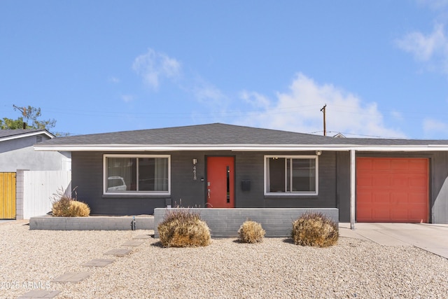 ranch-style house featuring driveway, fence, a garage, and roof with shingles