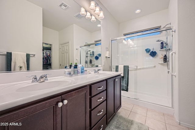 bathroom featuring tile patterned floors, vanity, and a shower with shower door