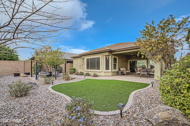 back of house with ceiling fan, a yard, and a patio