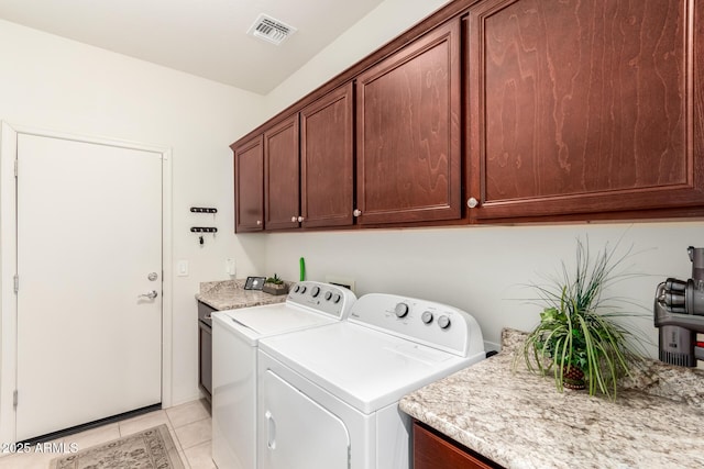 laundry area featuring cabinets, independent washer and dryer, and light tile patterned flooring