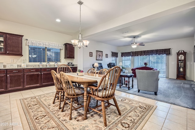 carpeted dining room featuring ceiling fan with notable chandelier