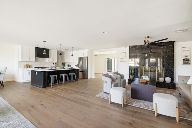 living room featuring ceiling fan, sink, and wood-type flooring