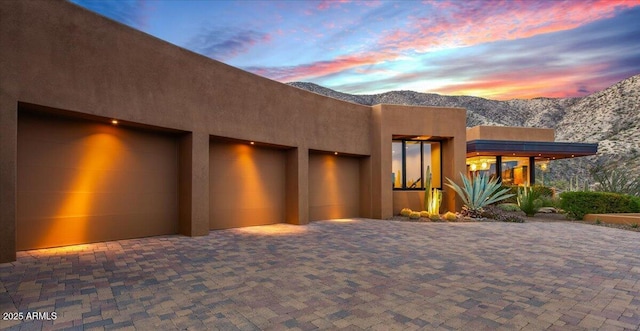 southwest-style home featuring a mountain view, stucco siding, and driveway