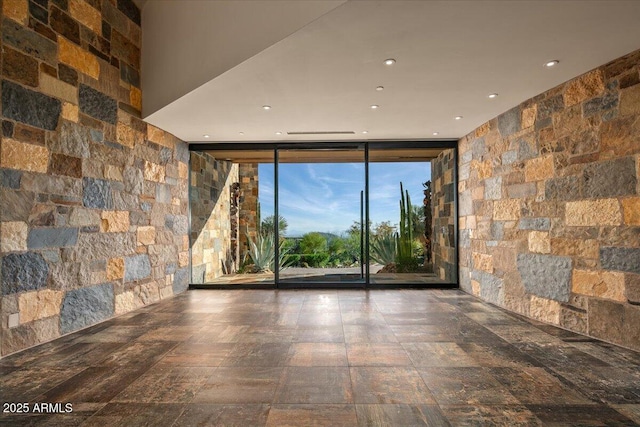 spare room featuring recessed lighting and a wall of windows