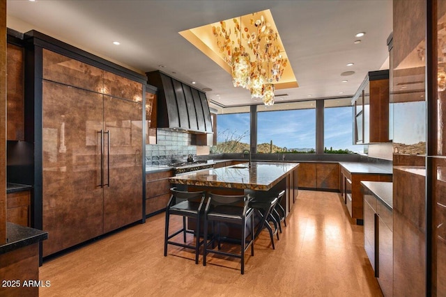 kitchen featuring recessed lighting, light wood-style floors, a sink, and dark stone counters
