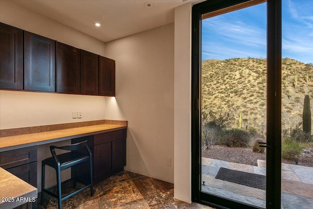 office featuring built in study area, recessed lighting, and stone finish floor