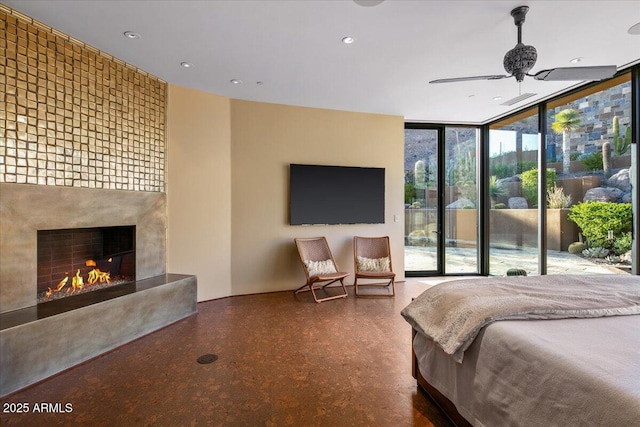 bedroom with access to exterior, recessed lighting, a fireplace, and a wall of windows