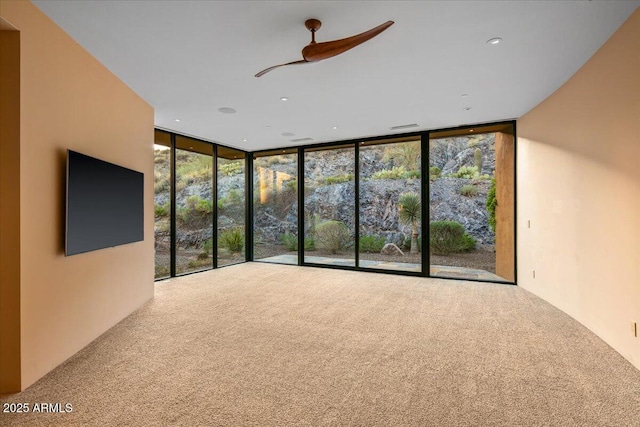 unfurnished living room with carpet flooring and a wall of windows