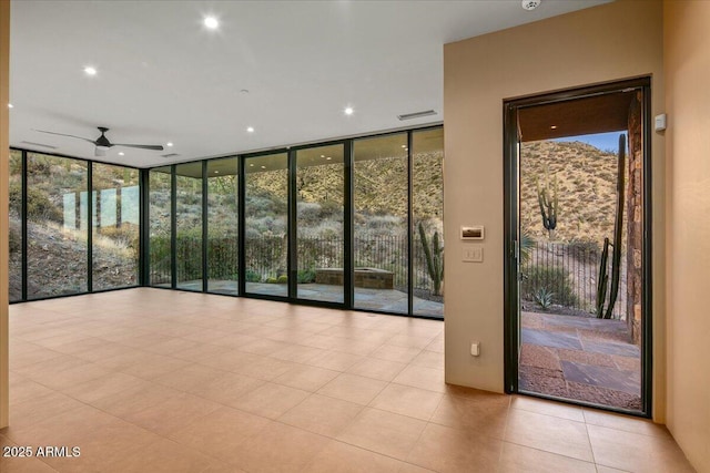 interior space with recessed lighting, ceiling fan, visible vents, and a wall of windows