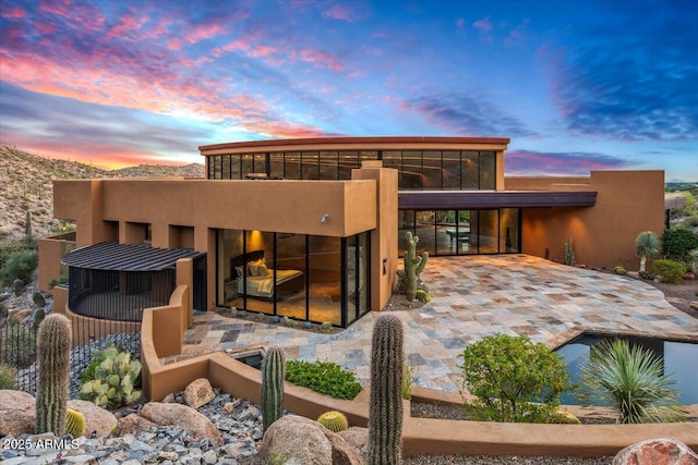 back of house at dusk with a sunroom