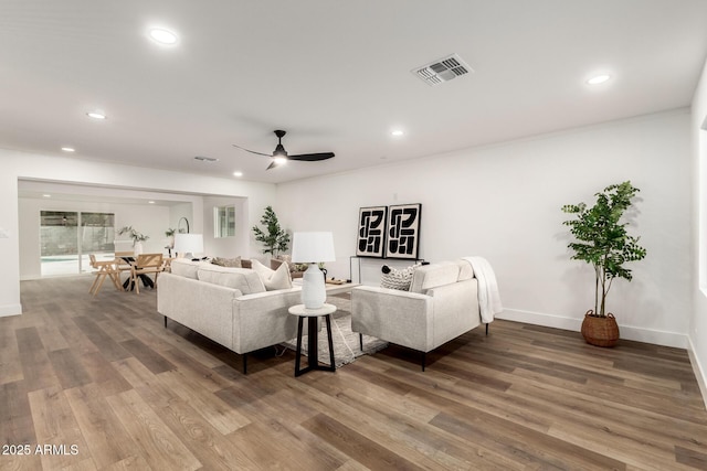 living room featuring hardwood / wood-style floors and ceiling fan