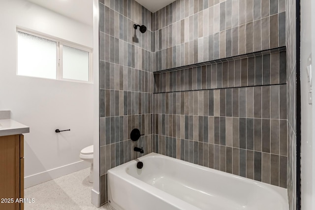 full bathroom with tiled shower / bath, vanity, and toilet