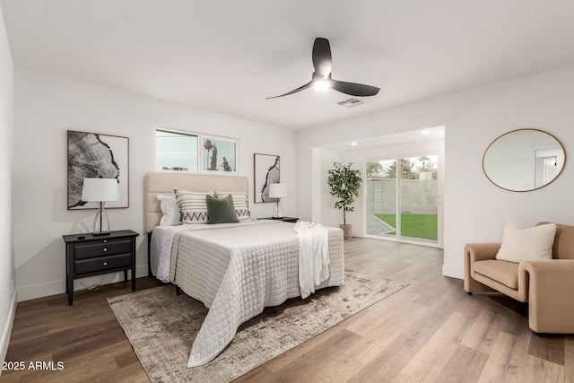 bedroom with hardwood / wood-style floors, access to outside, and ceiling fan