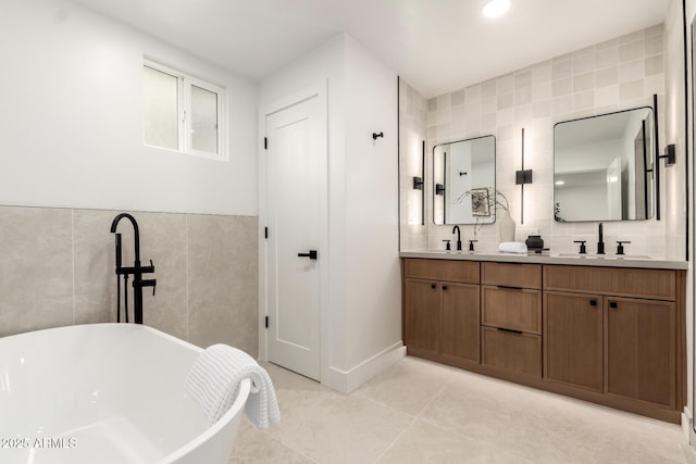 bathroom featuring a washtub, vanity, tile patterned floors, and tile walls