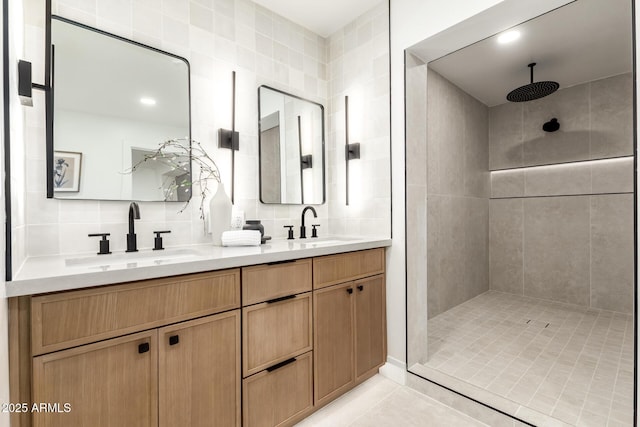 bathroom featuring a tile shower, tile walls, decorative backsplash, vanity, and tile patterned floors