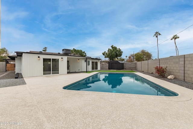 view of swimming pool featuring a storage shed and a patio area