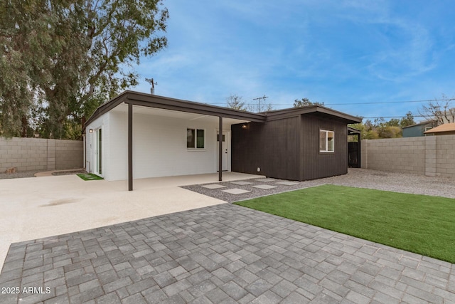 rear view of house with a yard and a patio area