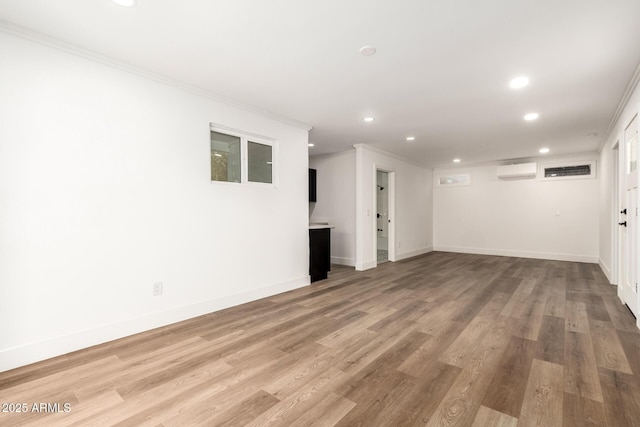 interior space featuring crown molding, light hardwood / wood-style floors, and an AC wall unit