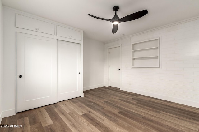 unfurnished bedroom with a closet, dark hardwood / wood-style floors, and ceiling fan