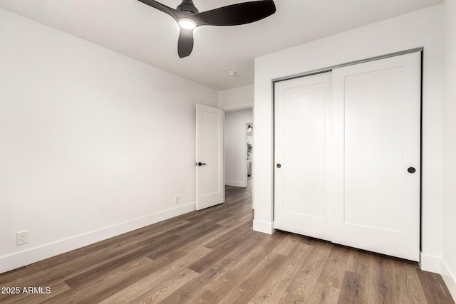 unfurnished bedroom with ceiling fan, wood-type flooring, and a closet