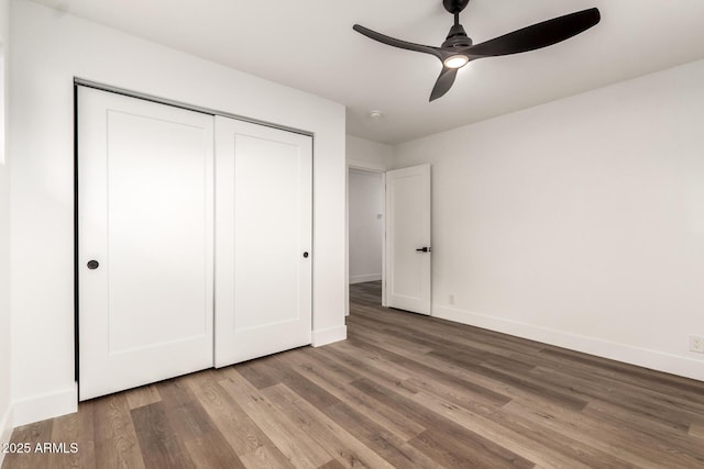 unfurnished bedroom featuring hardwood / wood-style floors, ceiling fan, and a closet