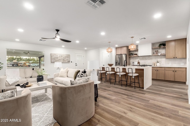 living room with light hardwood / wood-style floors and ceiling fan