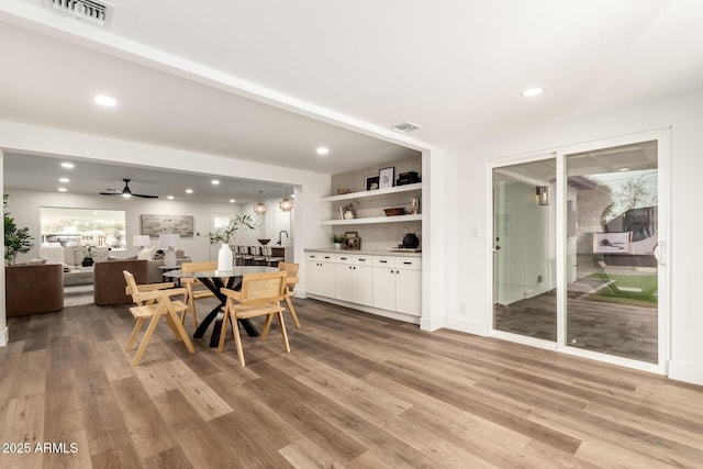 dining space with ceiling fan and light hardwood / wood-style flooring