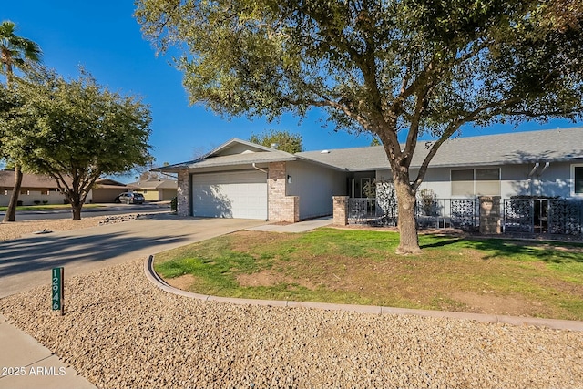 single story home featuring a garage, brick siding, fence, concrete driveway, and a front yard