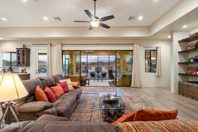 living room with ceiling fan and light wood-type flooring