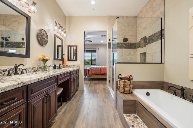 bathroom with ceiling fan, vanity, separate shower and tub, and hardwood / wood-style floors