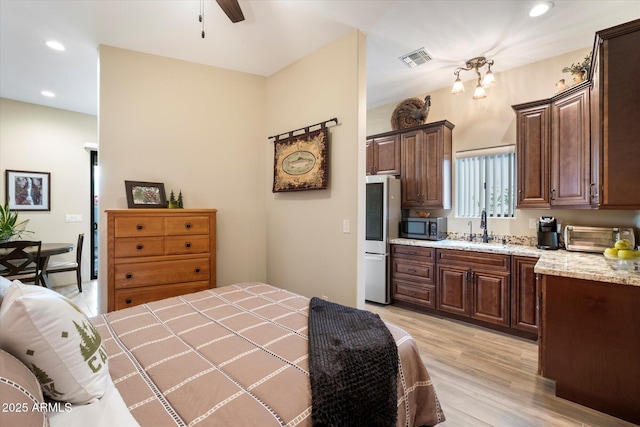 bedroom featuring sink, stainless steel fridge, and light hardwood / wood-style floors