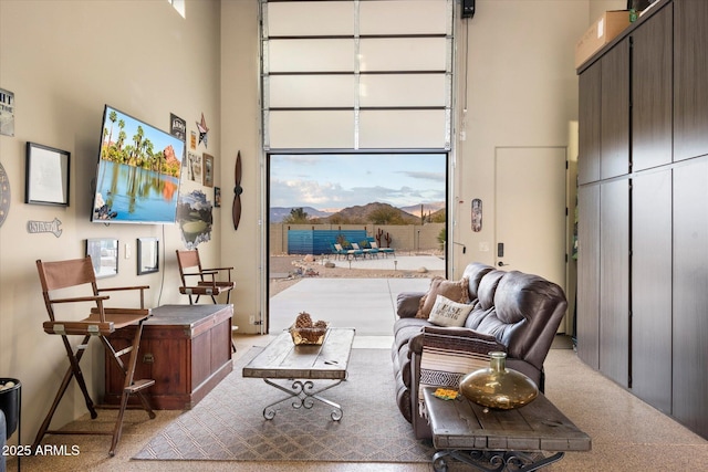 sitting room featuring a high ceiling and light carpet