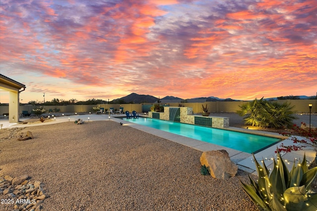 pool at dusk with a patio