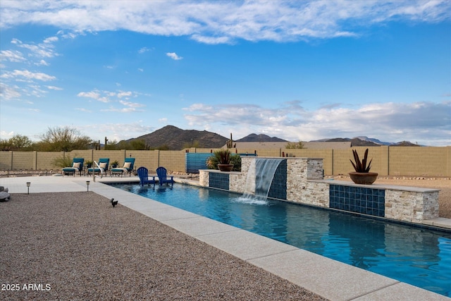 view of pool with a patio, a mountain view, and pool water feature