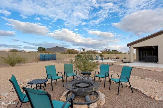 view of patio with an outdoor fire pit and a mountain view