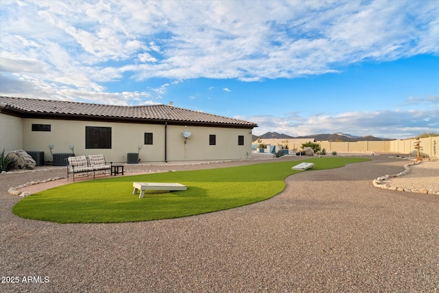 back of house with cooling unit and a yard