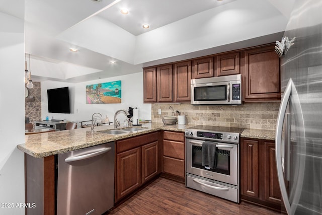 kitchen with sink, stainless steel appliances, tasteful backsplash, light stone countertops, and kitchen peninsula